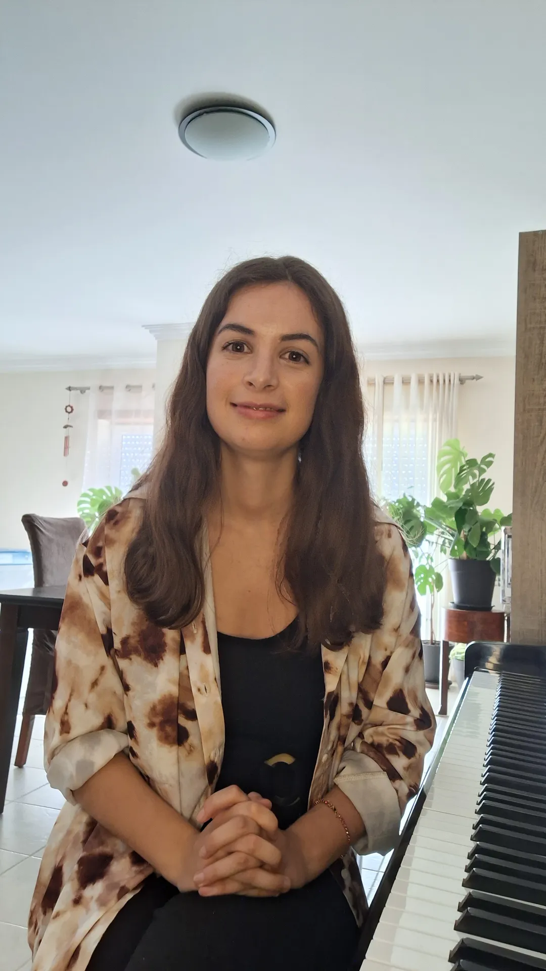 Mariana, professora de piano, sentada ao piano